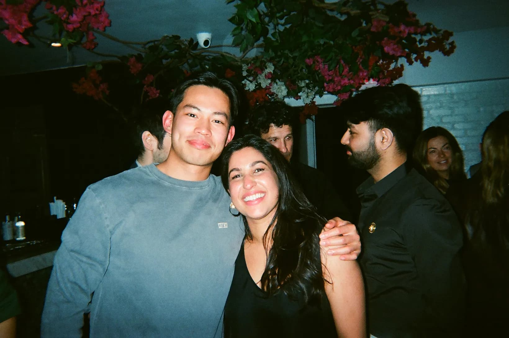 Two Rogo teammates smiling under flowering branches at a team evening